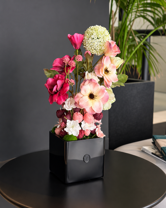 Belladonna, a tall candle bouquet of blush, ivory and burgundy olive wax flowers in a black square vase