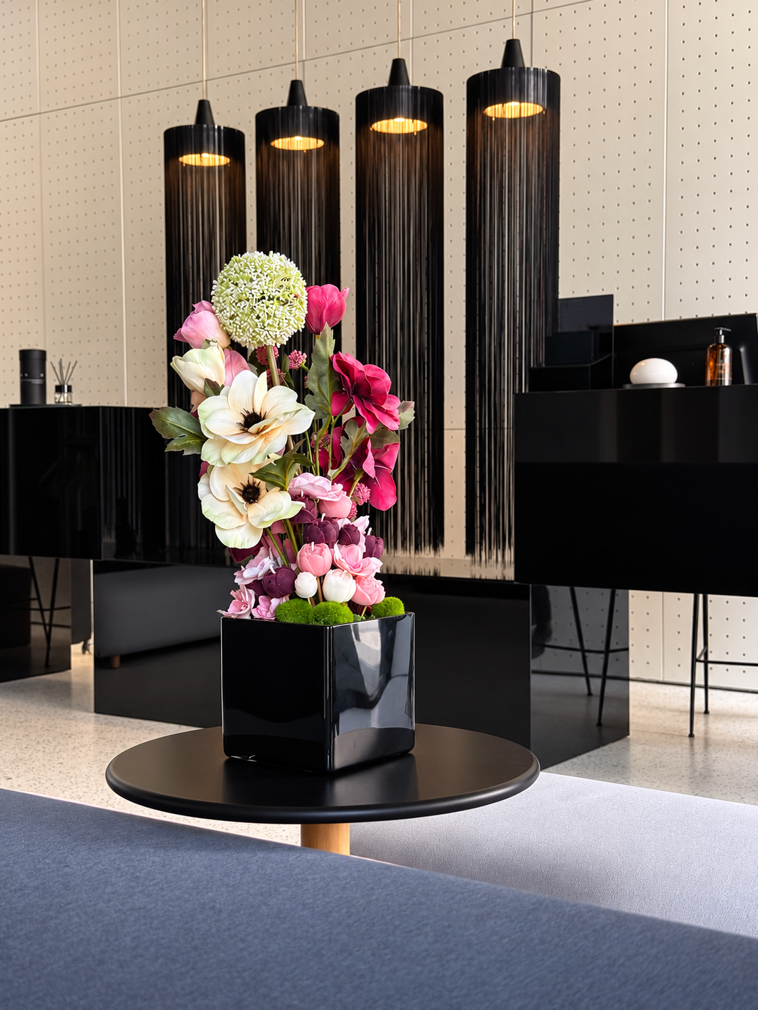 Belladonna, a tall candle bouquet of blush, ivory and burgundy olive wax flowers in a black square vase